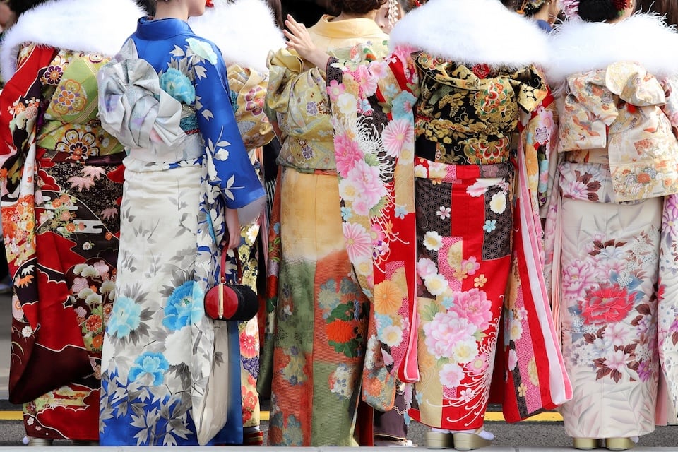 Young women in colorful furisode kimonos celebrating Coming-of-Age Day with friends.