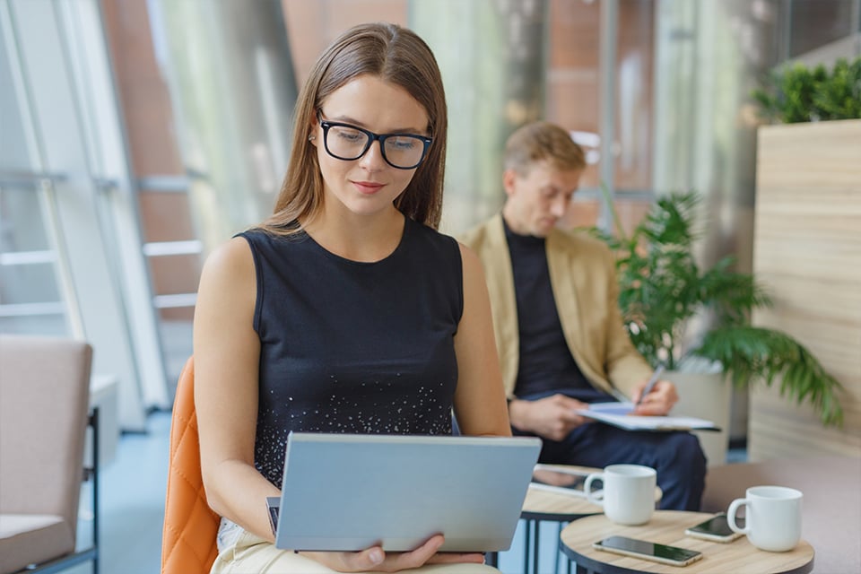 Businesswoman planning a Mt. Fuji Hakone day trip from Tokyo on a laptop